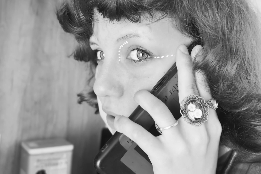 Kadr z filmu "Inwazja z Fantazji". Osoba rozmawia przez telefon.