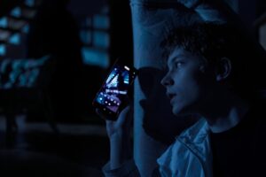 Kadr z filmu "Niedaleko pada jabłko". Chłopak robi komuś zdjęcie z ukrycia.