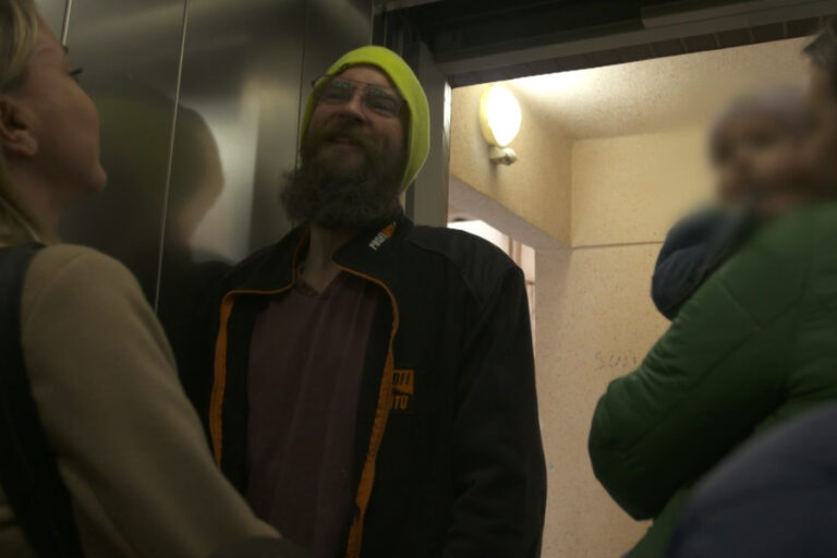 Kadr z filmu "Wstyd". Rozmowa kilku osób w windzie.
