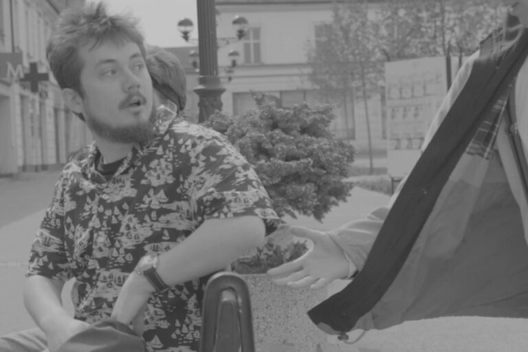 Kadr z filmu "C'est la vie". Rozmowa dwóch osób na ulicy.